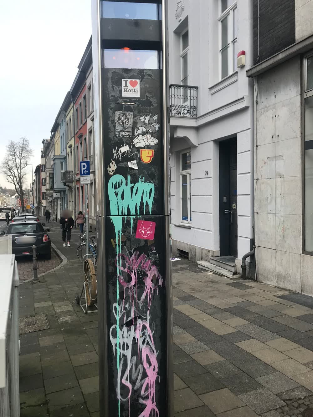 Messsäule in der Innenstadt mit Aufklebern und Graffiti vor der Behandlung